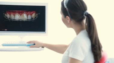 Diş hekimi hastaya dişlerini bir görüntüsünü gösterir.