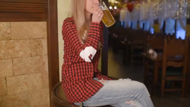 Pretty girl with a glass of beer on the background of a bar — Stock Video