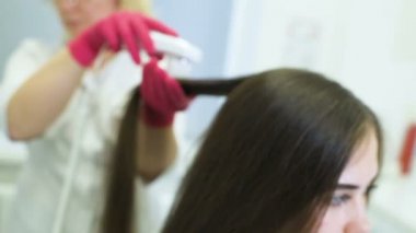 özel bir araç - bir trichoscope ile güzel bir genç kız saç yapısını Doktor dermatolog tanılar.