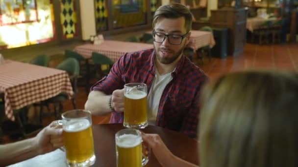 Φίλους να επικοινωνούν και να πίνουν μπίρα σε μια καφετέρια ή ένα μπαρ — Αρχείο Βίντεο
