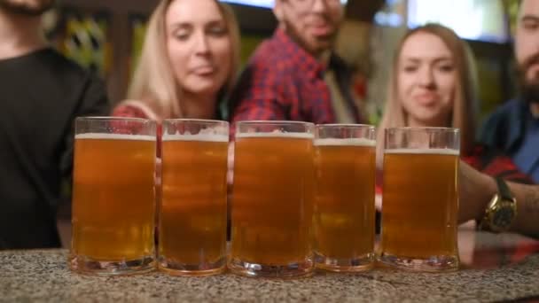 Freunde - junge Burschen und Mädchen trinken Bier, reden und lächeln an der Bar — Stockvideo