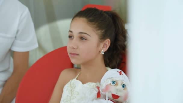 Meisje van de baby in rode tandheelkundige stoel bij de receptie van een tandartsen — Stockvideo