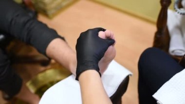 Genç bir kadın bir erkek pedikür güzellik salonu arka planda yapar..