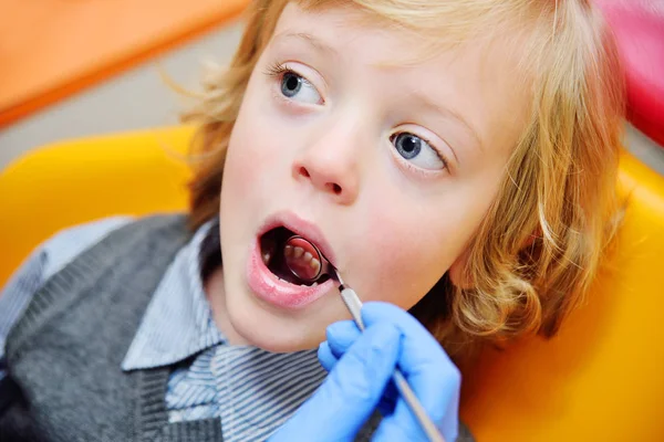 Menino sorrindo com cabelo encaracolado loiro na cadeira dental . — Fotografia de Stock