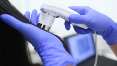 özel bir araç - bir trichoscope ile güzel bir genç kız saç yapısını Doktor dermatolog tanılar.
