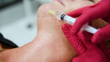 Doktor güzellik uzmanı dermatolog Mezoterapi bir oturum için yaşlı bir kadın yapar..