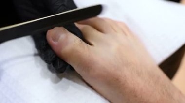 Pedikür ana parmak tırnak bakım müşteri adamlar spa salonu zemin üzerine yapıyor