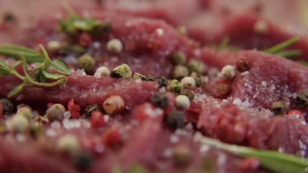 Vers rauw rundvlees vlees close-up met kruiderijen - paprika's, zout. Voorbereiding voor het grillen. — Stockvideo