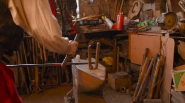 elinde bir araç ile bir demirci