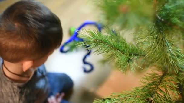 Niño decora árbol de Navidad con juguetes en casa — Vídeos de Stock