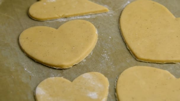 Kvinde confectioner skærer hjerter ud af dejen til bagning honningkager – Stock-video