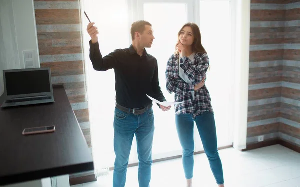 Inmobiliaria, corredor o propietario muestra un apartamento a una mujer joven. Ella va a firmar un contrato de arrendamiento con él . — Foto de Stock