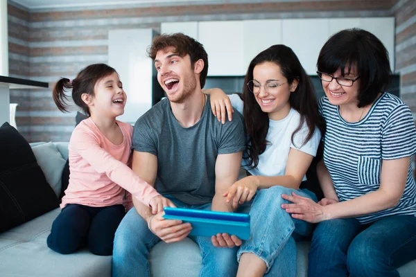 Velká rodina doma. Všichni společně komunikují online konference na tabletu. Nebo hrát zábavnou mobilní hru — Stock fotografie