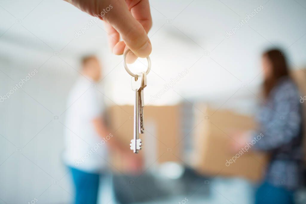 The keys in the hands of the apartment close-up. Against the background of a young seven moves to a new house