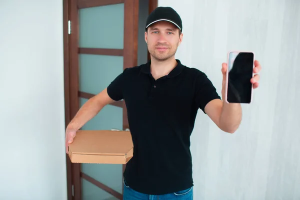 Food delivery concept. Pizza Delivery Man Shows App On Smartphone For Delivery
