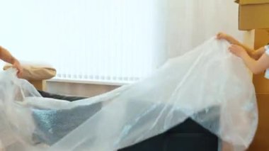 Genç çift yeni bir daireye taşınıyor. Kanepeyi çıkarın ve birlikte oturun. Genç adam ve kadın kucaklaşır ve anın tadını çıkarırlar..