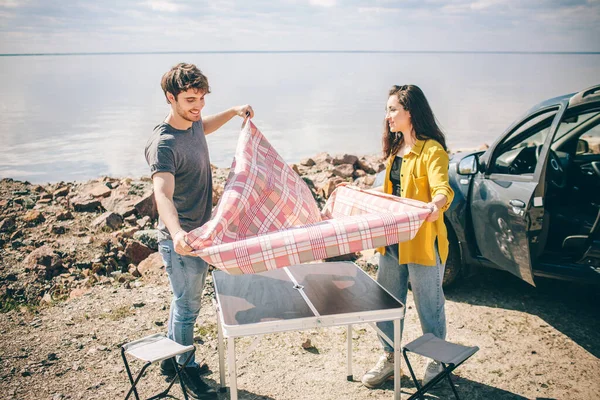 Piknik a víz mellett. Boldog család autókiránduláson. Férfiak és nők utaznak a tengeren, az óceánon vagy a folyón. Nyári utazás autóval. — Stock Fotó