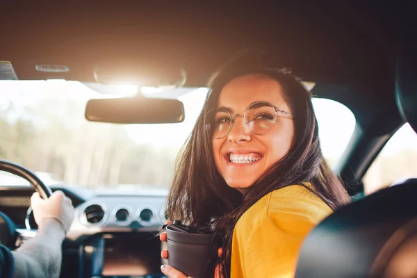 Viaggi, turismo Bella donna con un paio di tè o caffè sorridente mentre seduto sul sedile in auto — Foto Stock