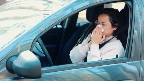 Junge Frau sitzt in Reisepause im Auto Niesen ins weiße Gewebe. Kranke Mädchen leiden unter Kopf- und Brustschmerzen. Schlechter Gesundheitszustand. — Stockvideo