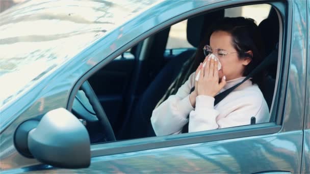 Jeune femme assise en voiture pendant la pause voyage. Le mouvement lent de la jeune fille souffre de la maladie. Une femme malade soufflant dans un tissu blanc. Seul dans la voiture. — Video