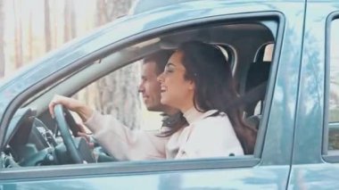 Genç bir adam ve bir kadın ormanda birlikte araba sürüyorlar. Neşeli pozitif kadın sürücü ve eğitmeni yan yana oturur. Kız, erkek konuşurken düz gider..