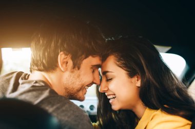 Turizm - Mutlu genç adam ve kadın Happy arabada oturuyor. Seyahat ve macera konsepti.