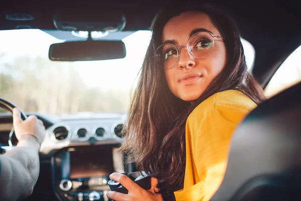 Reizen, toerisme - Mooie vrouw met een paar thee of koffie lachend op de stoel in de auto — Stockfoto