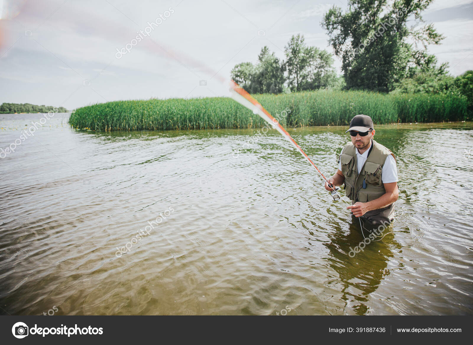 Young fisherman fishing on lake or river. Picture of guy in robe