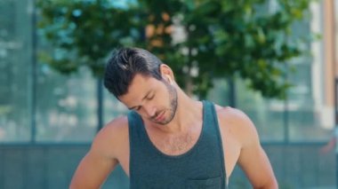 Genç adam dışarıda egzersiz yapıyor. Ağır çekimde bir adam kulağına kulaklık taktı ve aynı yerden hızla koşmaya başladı. Sporcu eğitimi yoğun. Dışarıda sıkı çalış..