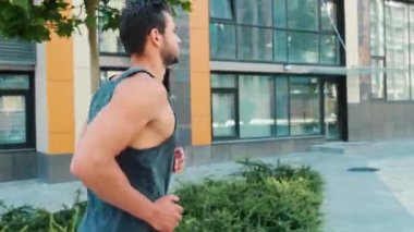 Genç adam dışarıda egzersiz yapıyor. Güçlü, kaslı, güçlü bir adamın sokakta tek başına koşuşunun arkası. Egzersiz ya da incelik aktivitesi. Sağlık ve iyi durumla ilgilenmek.