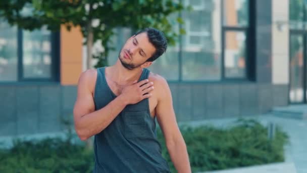 운동하는 젊은이. 훈련 전에 몸을 따뜻하게 하는 남자의 영상 과정. 거리에서의 힘든 집중 작업을 위한 인쇄. 도시 건물 전경. — 비디오