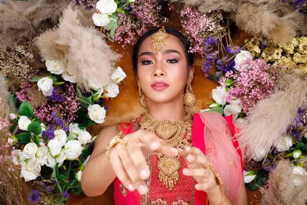 インドの美しさの顔は完璧な結婚式の花嫁を構成します 重いジュエリーと手を保持すると赤ピンクの伝統的なインドのブライダル衣装の美しい女性の肖像画 — ストック写真