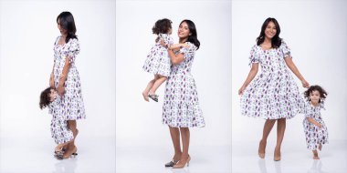 Asyalı anne ve beyaz kız aynı Mor çiçekli elbiseyi giyerler. Küçük kız annenin elini tut ve sevgiyle gülümse. Beyaz arkaplan izole