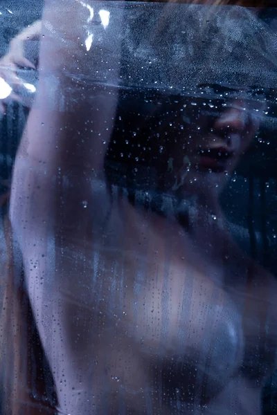 性感的裸体女性 赤裸裸的性感美女在黑暗的背景下 亚洲女人的情色姿势在浴室的淋浴玻璃蒸汽中激起了浅浅的阴影和轮廓 — 图库照片