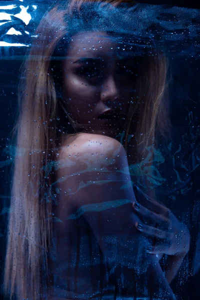 Seksi, çıplak bir kadın. Çıplak, şehvetli, güzel kız. Asyalı kadın erotik pozlar. Banyo banyosunda hafif gölge ve siluet hissi uyandırıyor. Karanlık arka planda cam buhar.