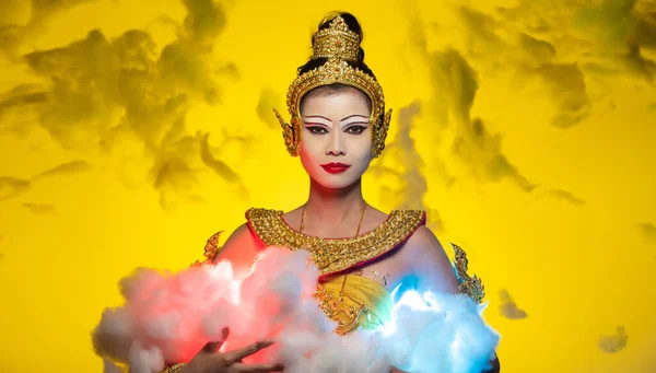 カンボジア ミャンマーのヴィンテージドレスアジアの美しい女性のための伝統的な衣装や古代アジアの金の布角度のような黄色の空の背景に青い赤い雲を保持 — ストック写真