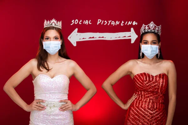 Group of Two Miss Beauty Queen Pageant Contest apply New Normal style to all contestant by wearing Protective Face Mask, Diamond Crown. Concept Social Distancing, Red Tone Background copy space
