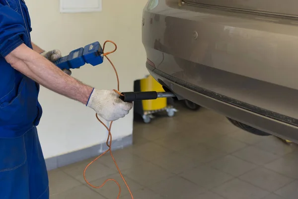 サービスステーションでの車の修理 プロの整備士が車の排気量を測定します 車の排気制御 ロイヤリティフリーのストック写真