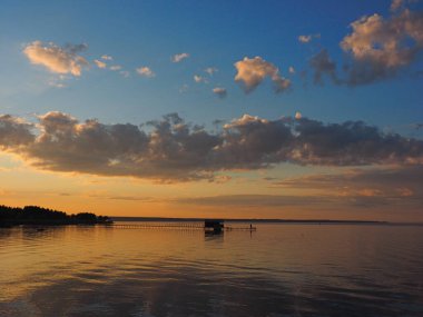 Gün batımı, yaz, gün batımında güzel bulutlar. Büyük Kama nehrindeki iskele. Ural, Rusya, Perma Bölgesi, Elovo.