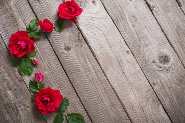 red roses on old wooden background