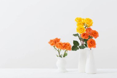 Beyaz arkaplanda beyaz vazodaki güller