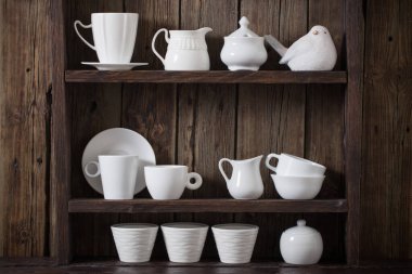 Eski siyah ahşap arka planda beyaz mutfak bulaşık takımı