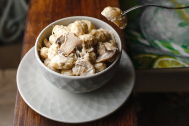 Patates gnocchi, peynir soslu İtalyan patates köftesi, mantar ve bir tabakta otlar. Yan görünüm, üst görünüm