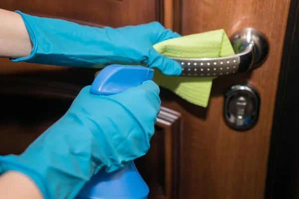 Una chica con guantes desinfecta la superficie con un antiséptico desinfectante . —  Fotos de Stock