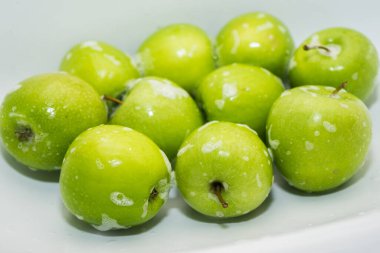 Meyve yıkıyorum. Lavaboda sabunlu yeşil elmalar. 