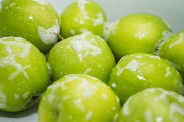 Meyve yıkıyorum. Lavaboda sabunlu yeşil elmalar. 