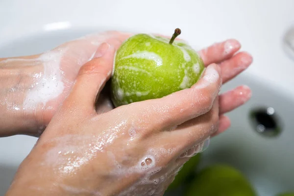 Mencuci buah. Gadis mencuci apel. Tangan dan sabun apel hijau — Stok Foto