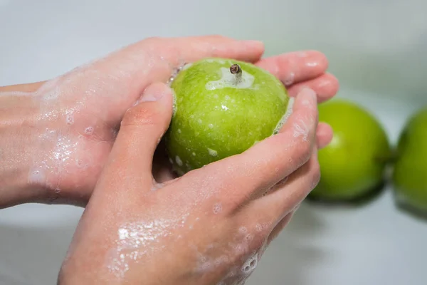 Mencuci buah. Gadis mencuci apel. Tangan dan sabun apel hijau — Stok Foto