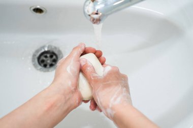 Sabunla el yıkama. Kız ellerini antibakteriyel sabunla yıkıyor. 