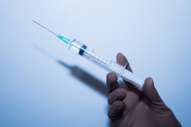 Doktorun elindeki şırıngada plastik eldiven var. Doktor aşı oldu.. 